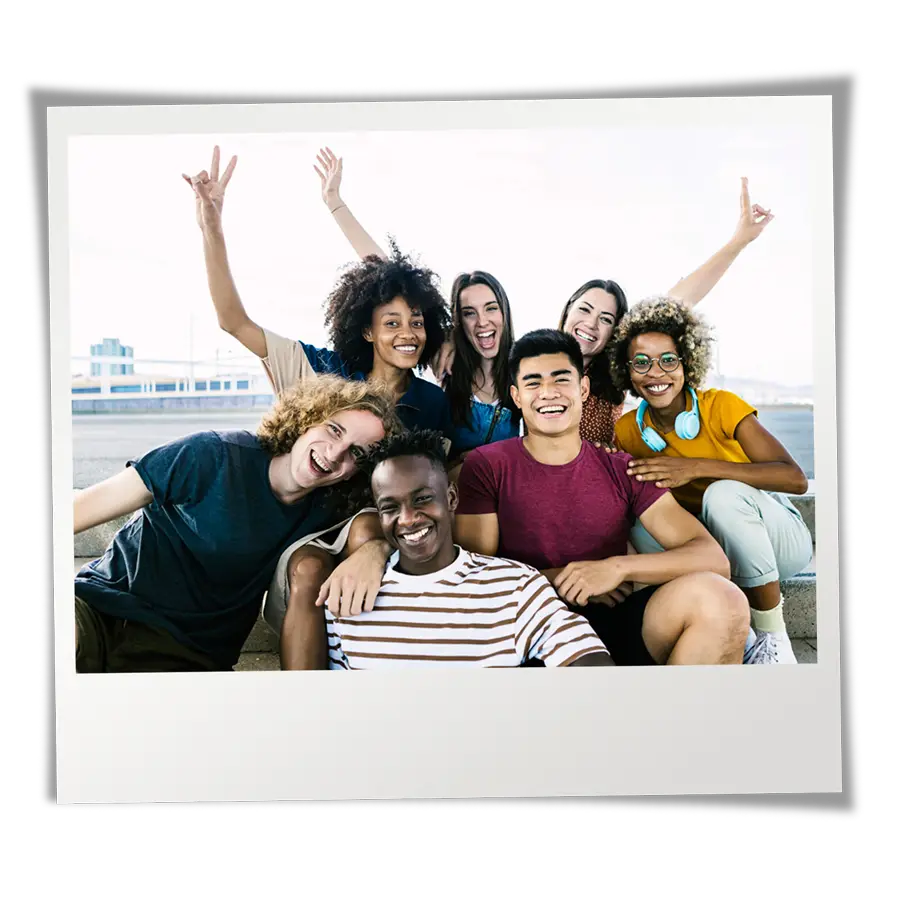 Group of racially diverse teens sitting together on steps and having fun.